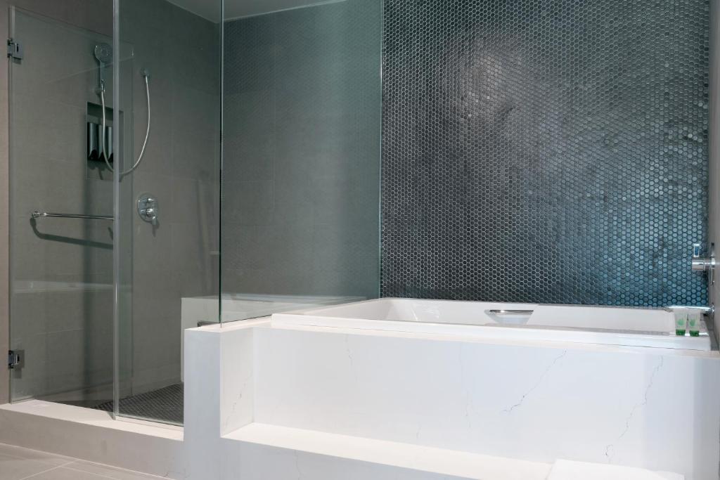 Tilbury Inn في غليندال: حمام مع دش مع حوض استحمام وباب زجاجي