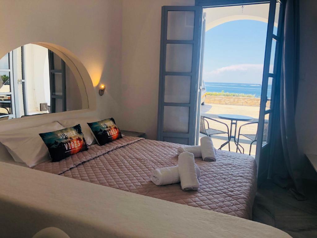 a bedroom with a bed with a view of the ocean at Santanna White Houses in Parikia