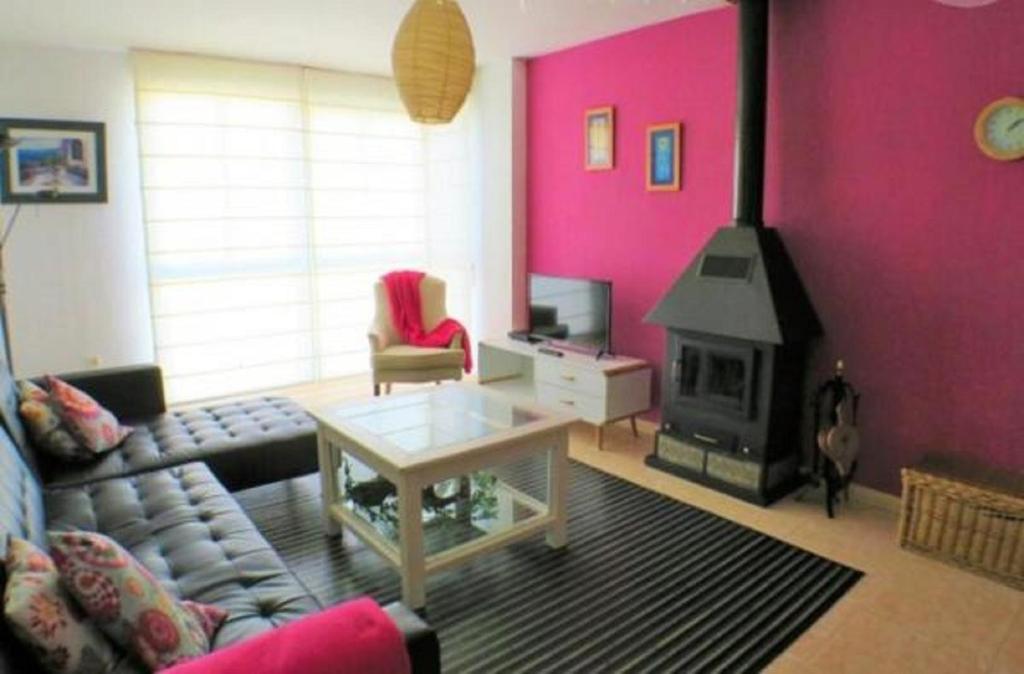 sala de estar con sofá y chimenea en Apartamento Belobodia, en Cáceres