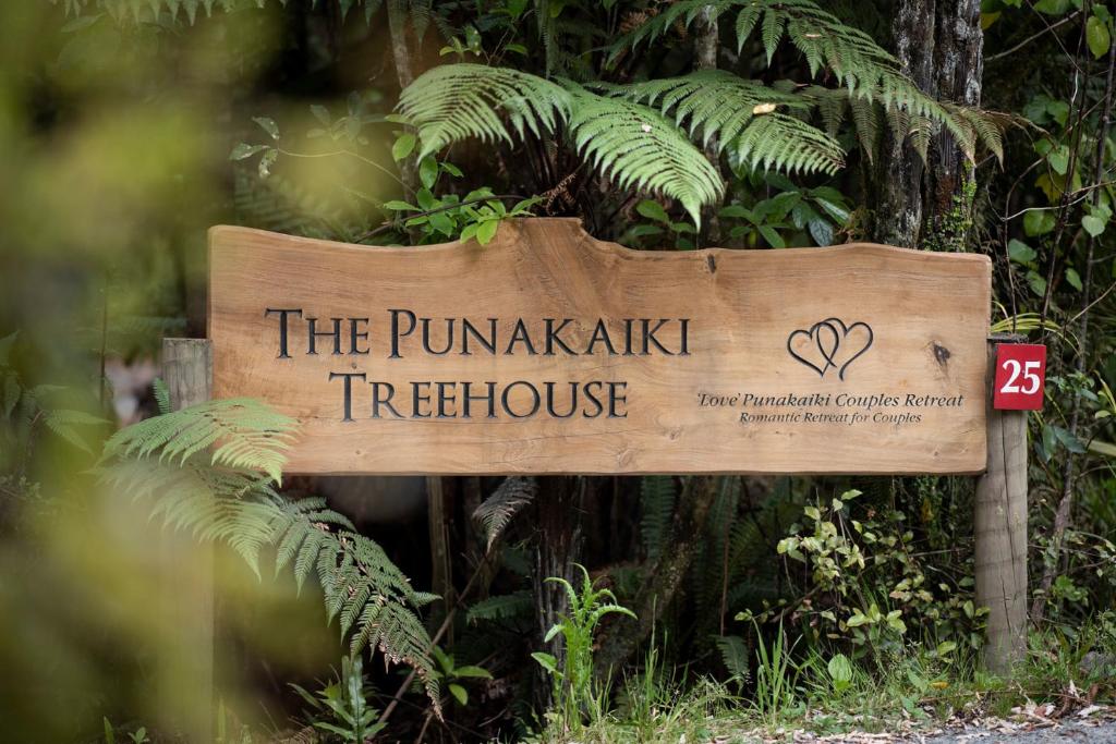 un cartel que lee la casa del árbol Runkakari en Punakaiki Treehouse Limited en Punakaiki