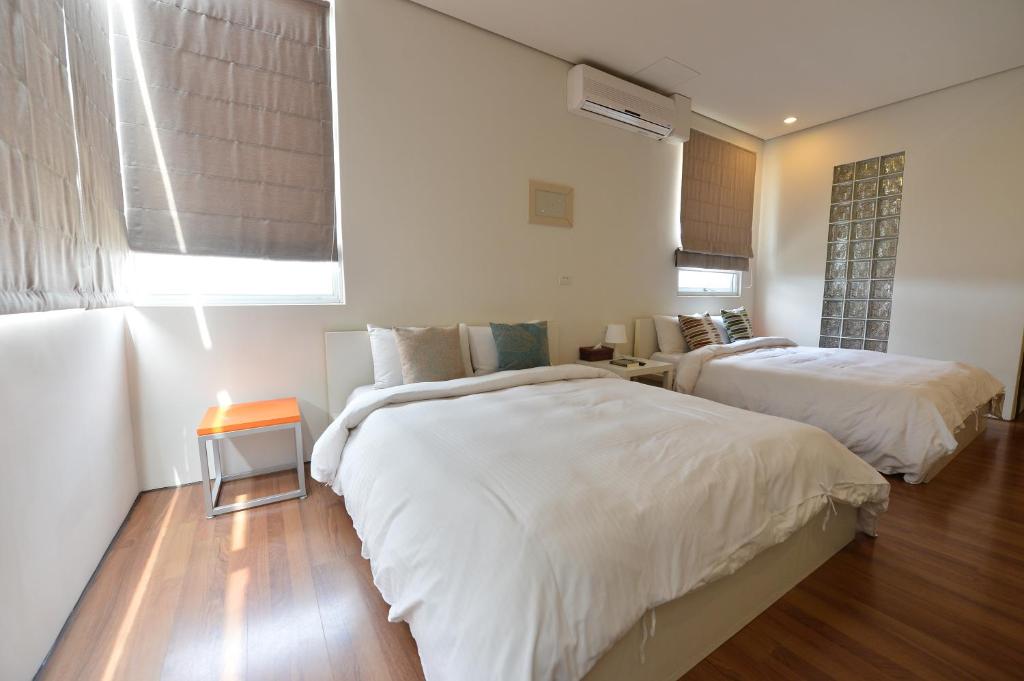 a bedroom with two beds and a window at Penghu Chenhi Bay Homestay in Baisha
