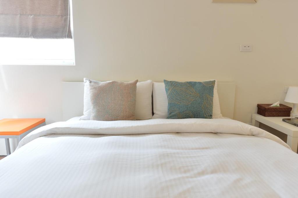 a bedroom with a bed with white sheets and pillows at Penghu Chenhi Bay Homestay in Baisha