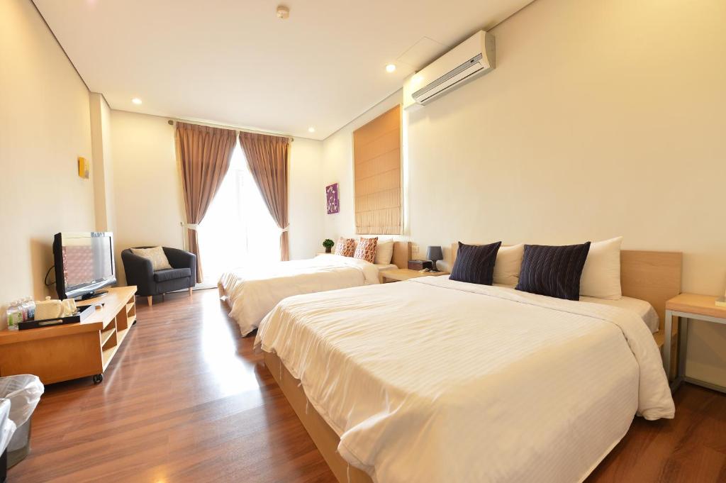 a hotel room with two beds and a television at Penghu Chenhi Bay Homestay in Baisha