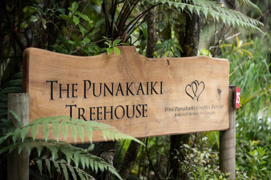 Love Punakaiki Luxury Couples Retreat Limited في بوناكايكي: علامة تشير إلى منزل شجرةممشى الينابيع