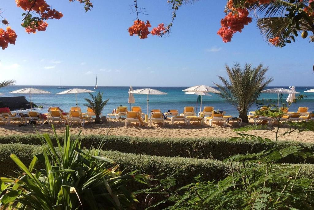 a beach with chairs and umbrellas and the ocean at Oceanfront Apartment 4 Porto Antigo II in Santa Maria