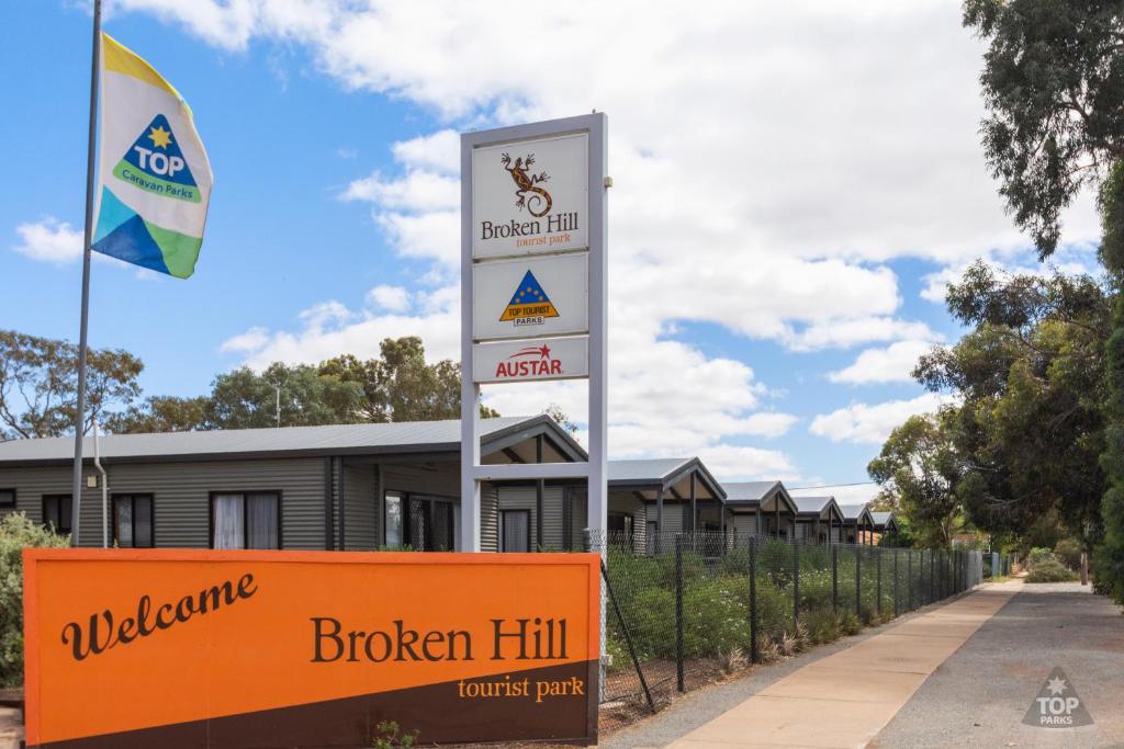 um sinal em frente a um edifício com uma cerca em Broken Hill Tourist Park em Broken Hill