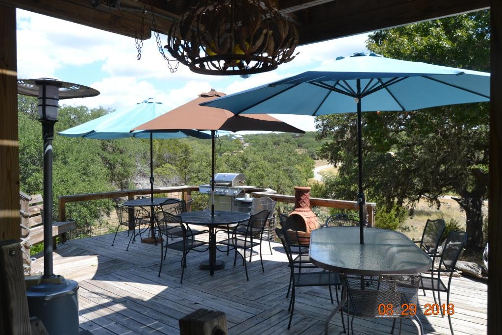 a deck with tables and chairs and umbrellas at Paradise at Canyon Lake in Canyon Lake