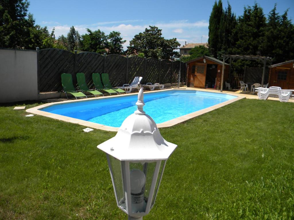 a swimming pool with a light in a yard at Gîte Domaine Bastide Jourdan in Bollène