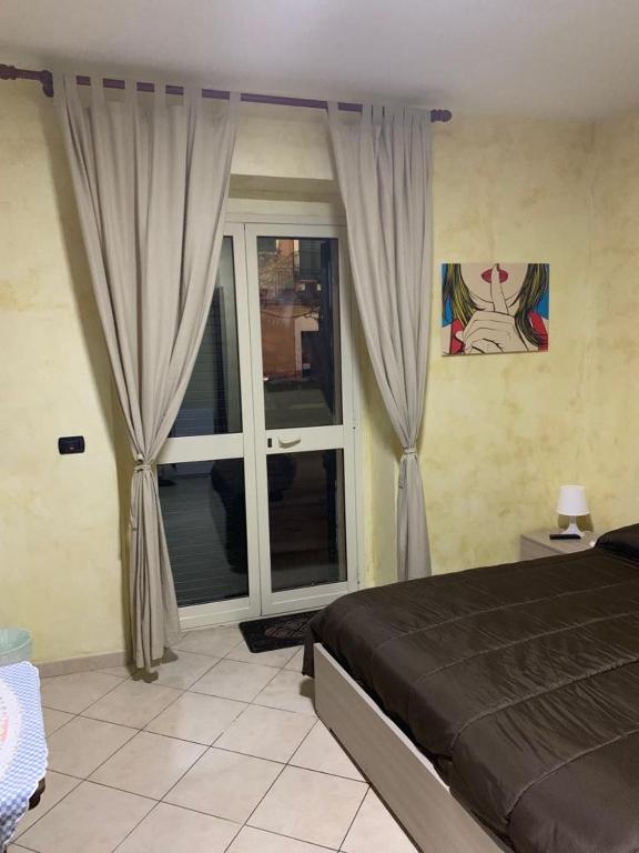 een slaapkamer met een bed en een groot raam bij Airport Bedroom House in Catania