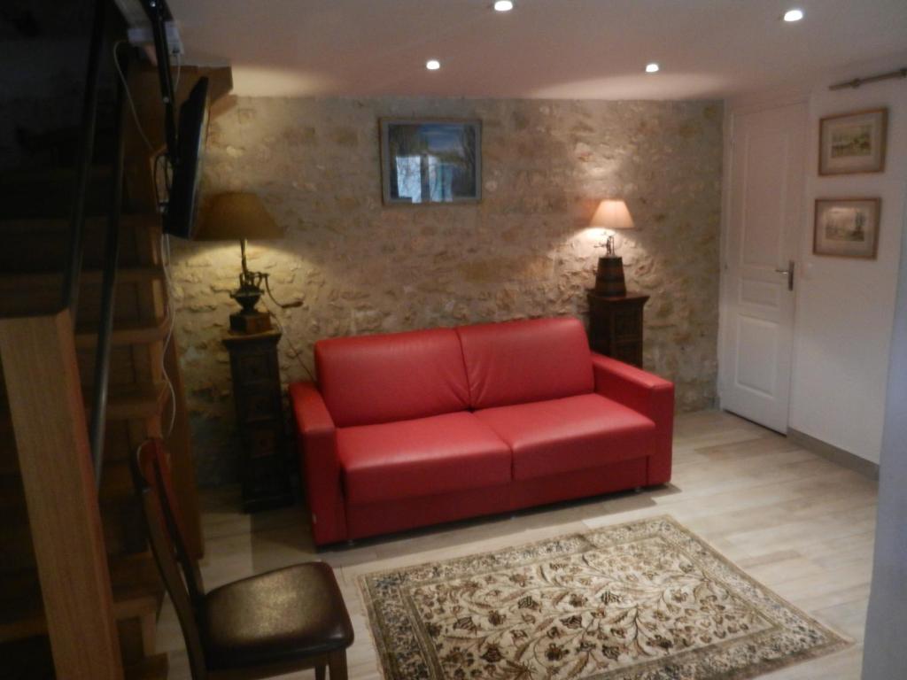 a red couch sitting in a living room at Chambres d'hôtes La Catounière in Fontainebleau