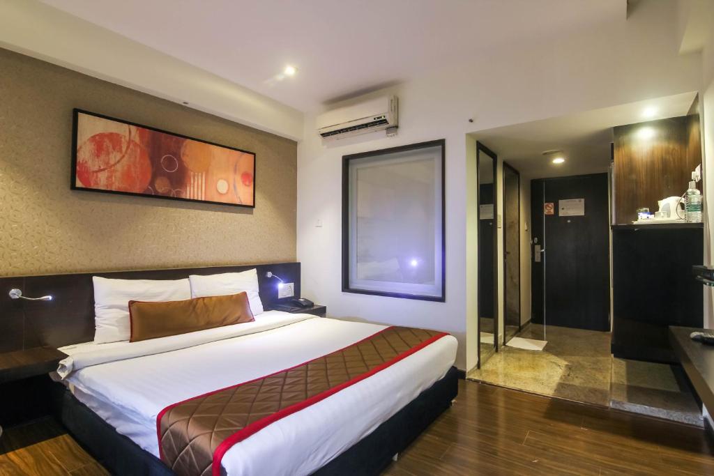 Hotel LXIA Hinjewadi - Indian Nationals Only tesisinde bir odada yatak veya yataklar