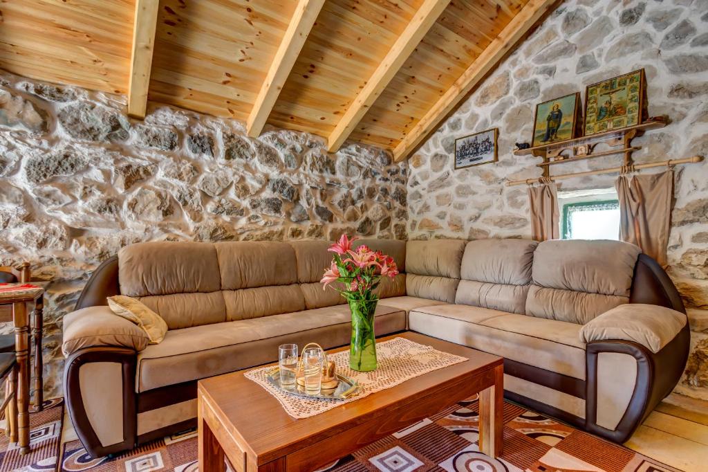 uma sala de estar com um sofá e uma mesa em Ethno House Kosic em Herceg Novi