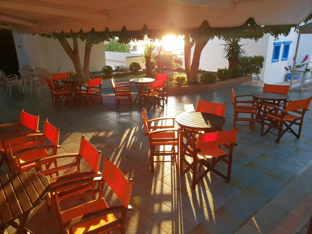 un grupo de mesas y sillas en un patio en Amazones Villas Apartments, en Stalida