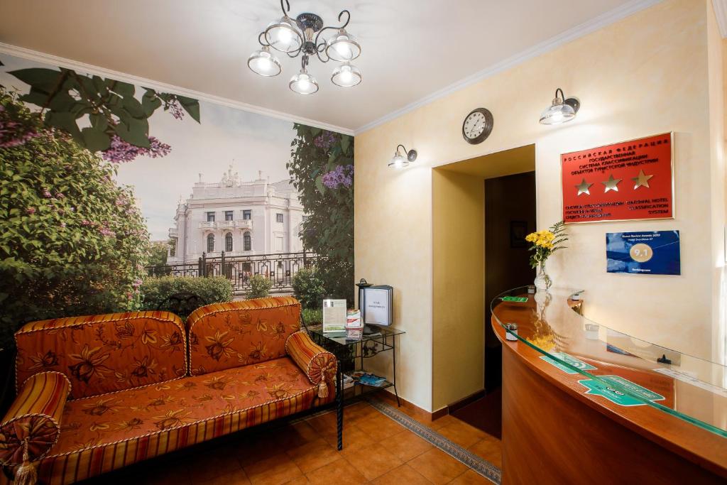 a living room with a couch in front of a wall at Hotel Sverdlova 27 in Yekaterinburg