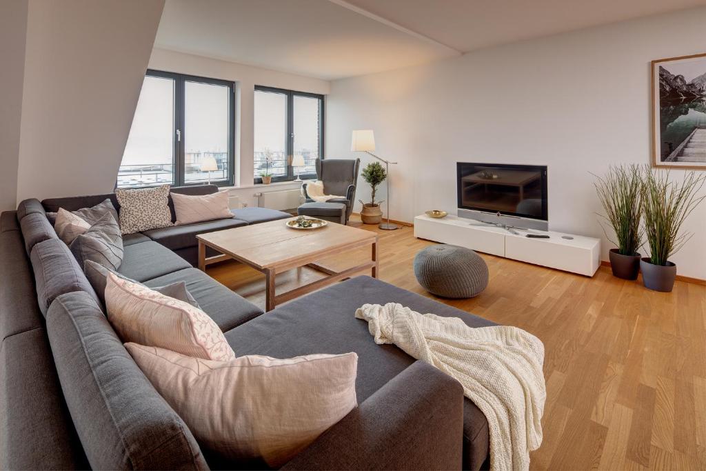 - un salon avec un canapé et une télévision dans l'établissement Ferienwohnung Fördepanorama in Flensburg, Sonwik, à Flensbourg
