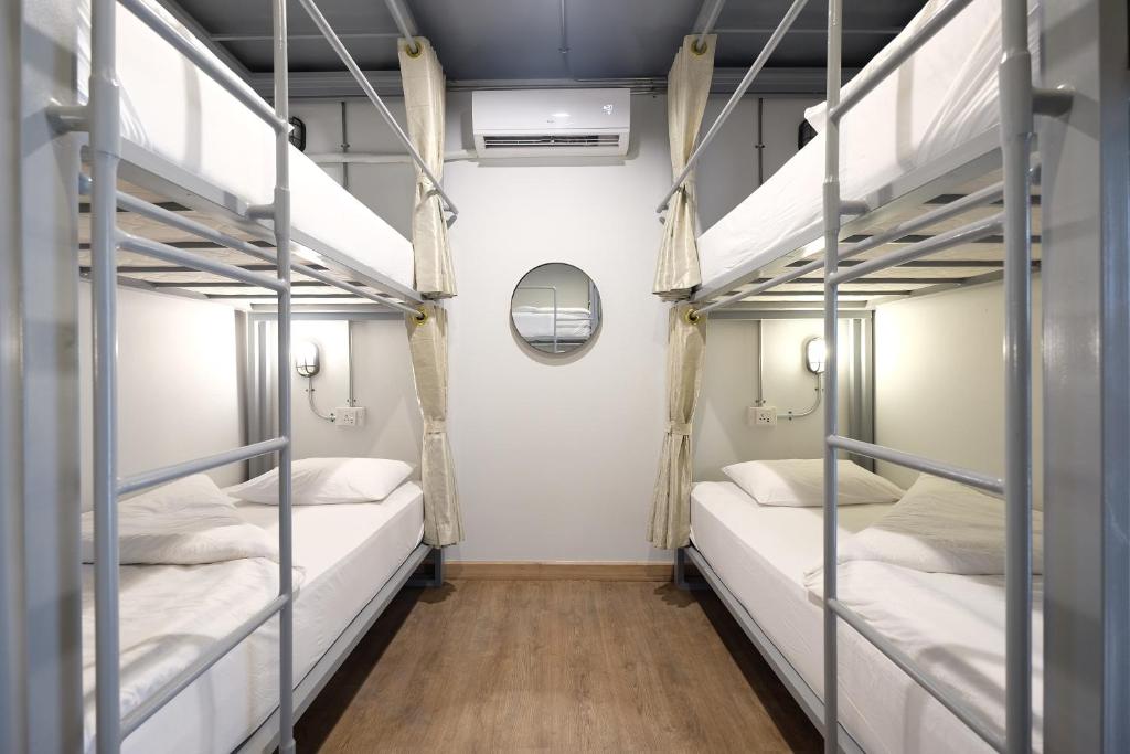 a room with two bunk beds with a mirror at Sailomyen Hostel in Vientiane