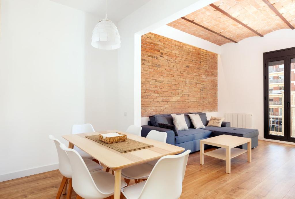 バルセロナにあるAkira Flats Urgell apartmentのリビングルーム(テーブル、青いソファ付)