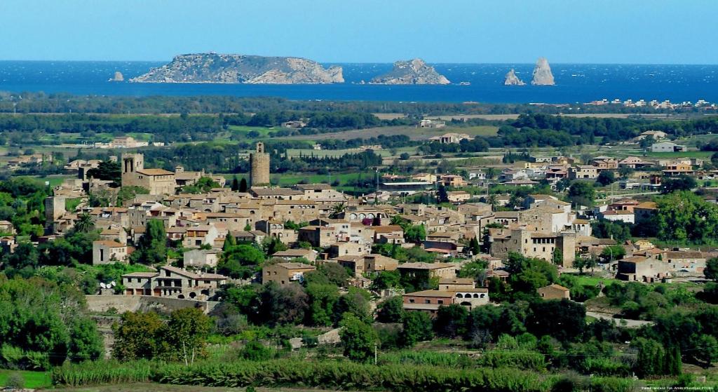 a small town with houses and trees and the ocean at La Costa Hotel Golf & Beach Resort in Pals