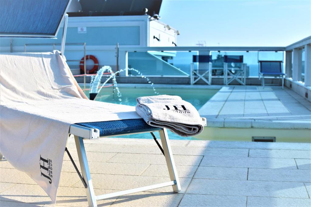 un asciugamano è seduto su una sedia accanto alla piscina di Hotel Villa Mare a Riccione