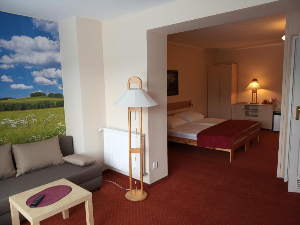 pokój hotelowy z łóżkiem i kanapą w obiekcie Pensjonat Willa Edyta w mieście Mrągowo