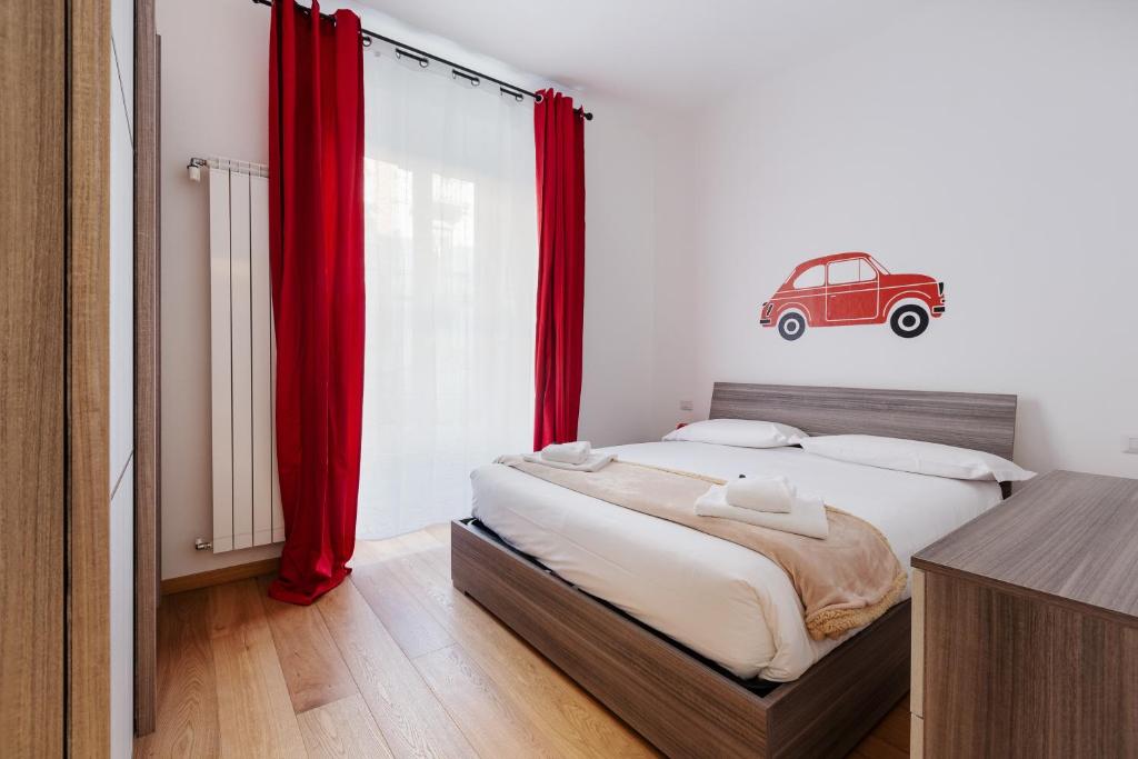 - une chambre avec un grand lit et des rideaux rouges dans l'établissement Buenos Aires & Lima Cosy Flat, à Milan