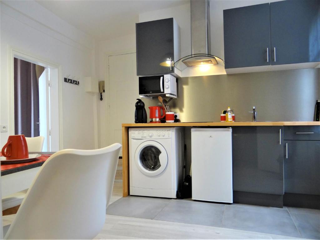 a kitchen with a washing machine and a washer at Les Clochers d'Or in Chartres