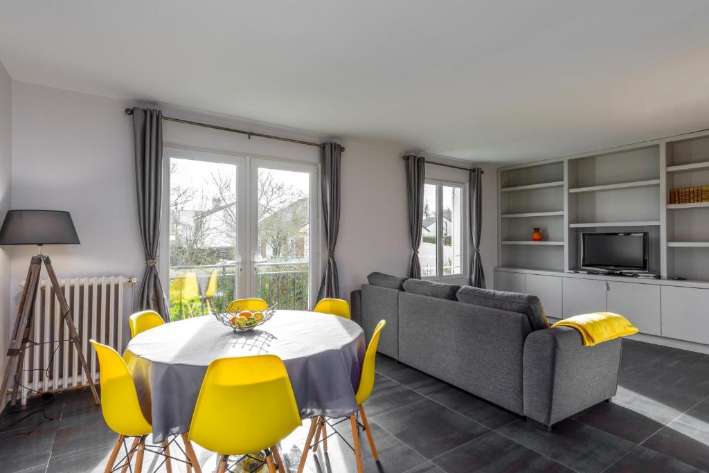 un salon avec une table et des chaises jaunes dans l'établissement 2 bed House near Disneyland Paris, à Montry