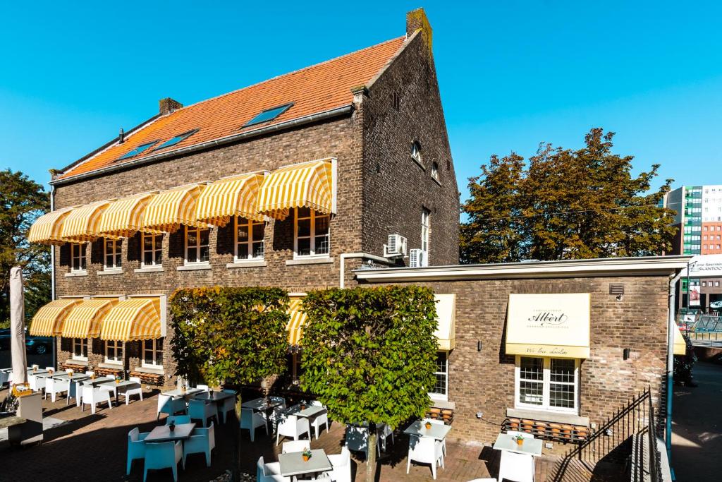 a building with tables and chairs in front of it at De Pastorie Bed & Breakfast in Roermond