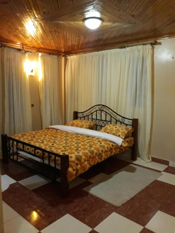 ein Schlafzimmer mit einem Bett in einem Zimmer in der Unterkunft Palm Airport Suites in Nairobi