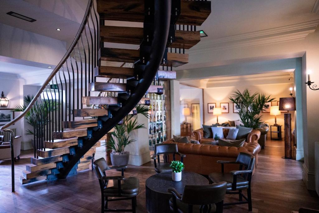 a staircase in a living room with a couch and chairs at Hotel du Vin & Bistro Harrogate in Harrogate