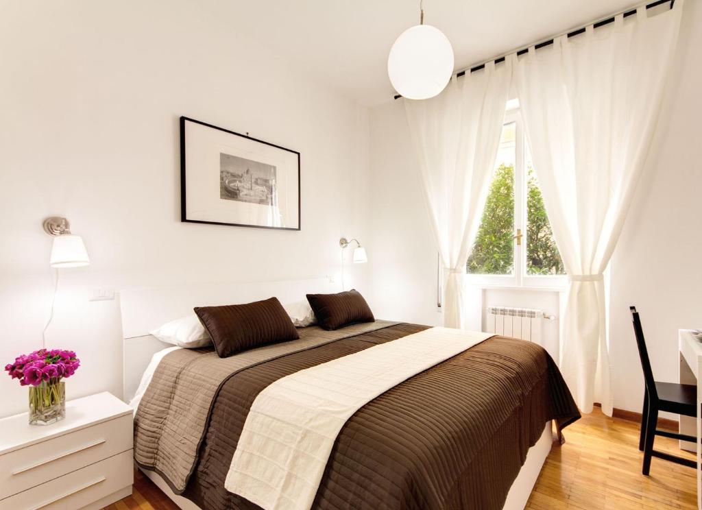 ein weißes Schlafzimmer mit einem Bett und einem Fenster in der Unterkunft Vatican Suites Happy Holidays in Rom