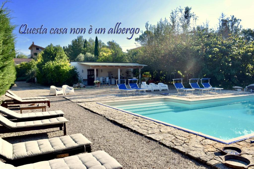 a swimming pool with lounge chairs and a house at Casa Cerqua Landi in Itri