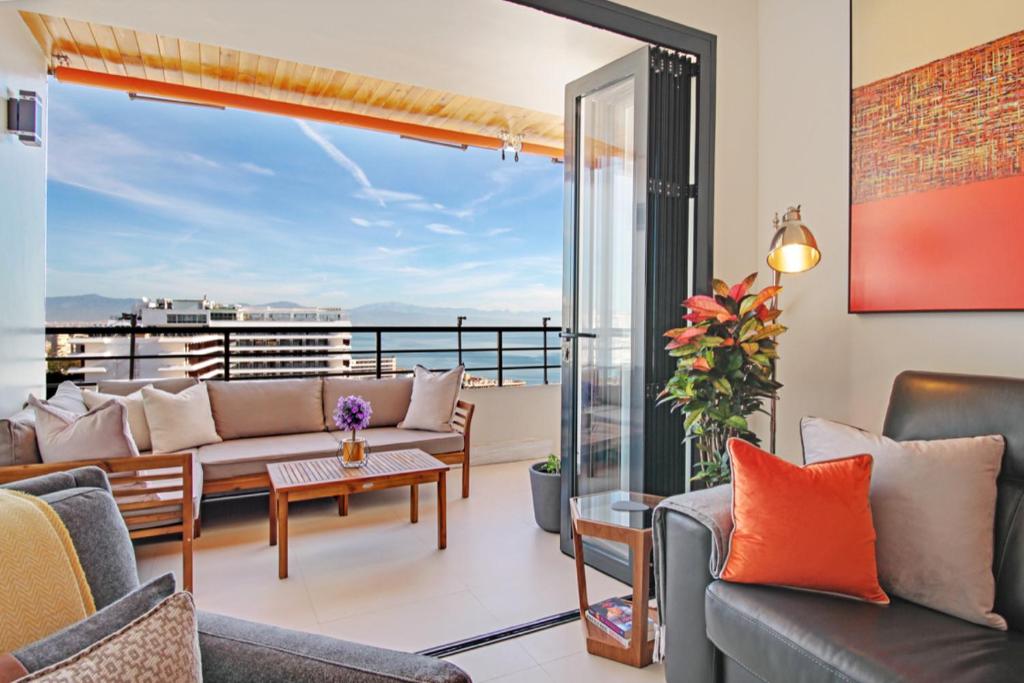 a living room with couches and a balcony at La Nogalera Deluxe Apartment Torremolinos in Torremolinos