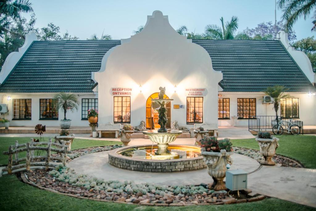 a house with a fountain in front of it at Loskop Valley Lodge in Groblersdal