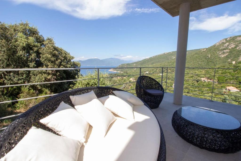 a patio with a table and chairs on a balcony at Villa neuve architecte vue mer in Belvédère