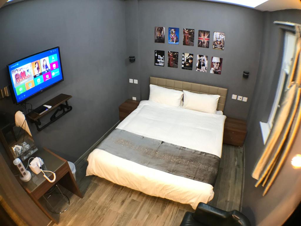 a small bedroom with a bed and a television at Soso Hostel in Hong Kong