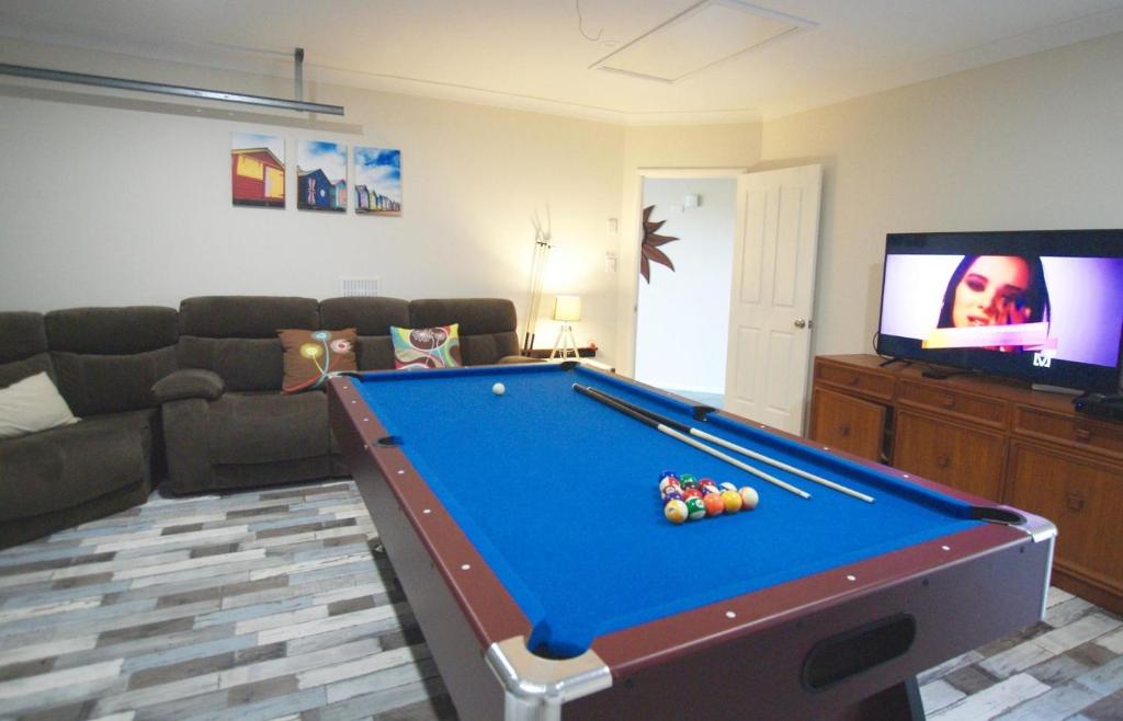 a living room with a pool table and a tv at Anaheim Entertainer by Getastay in Gold Coast