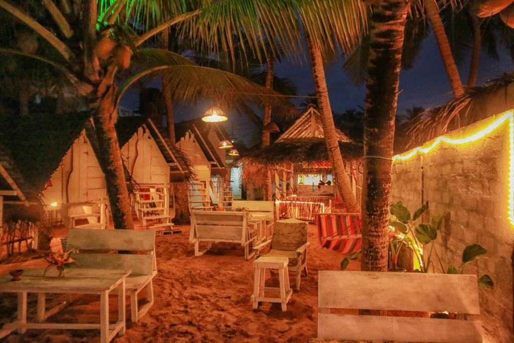 a beach with chairs and palm trees at night at Oynise Beach Cabin in Galle