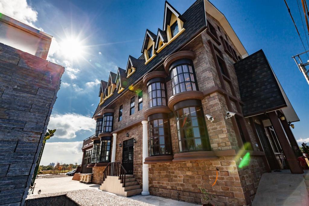 a large brick building with a gold sign on it at Hogwarts Castle Guest House in Wujie