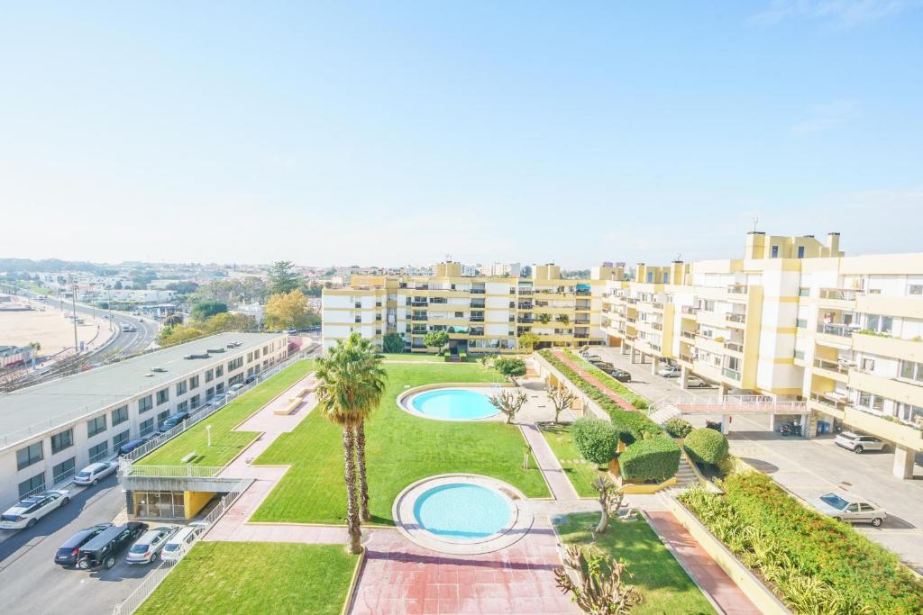 einen Luftblick auf einen Park mit Palmen und Gebäuden in der Unterkunft OceanFront & Big Terrace Private Condo in Oeiras