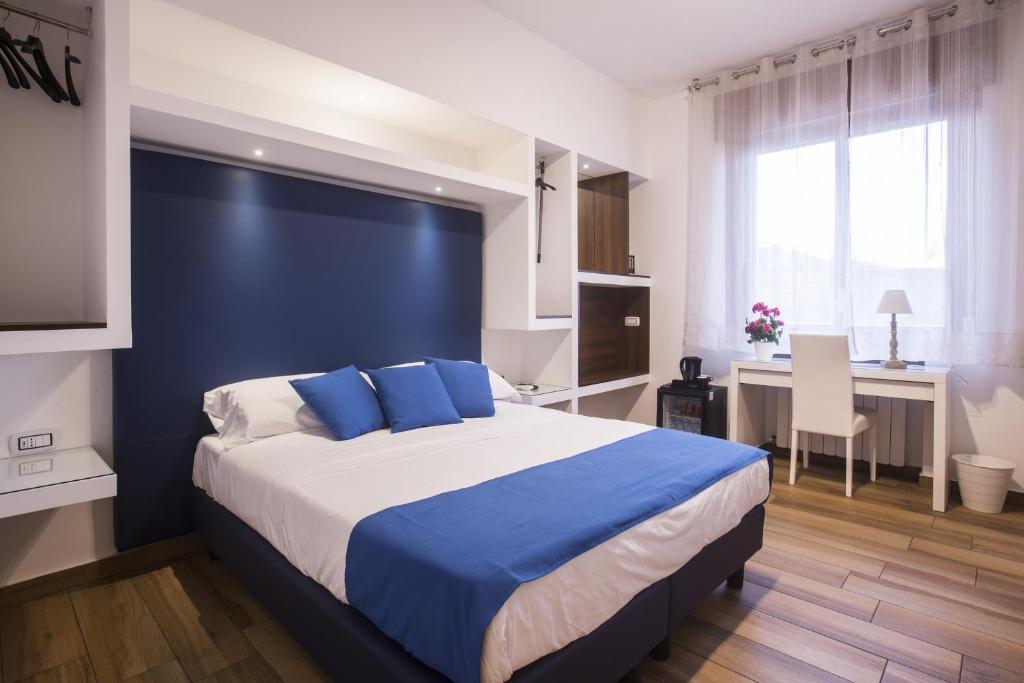 a bedroom with a large bed with blue pillows at Central Plaza Sorrento Coast in Sant'Agnello