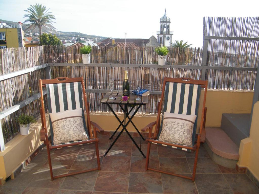 un patio con 2 sillas y una mesa con una botella de vino en Casa Rural San Francisco en Granadilla de Abona