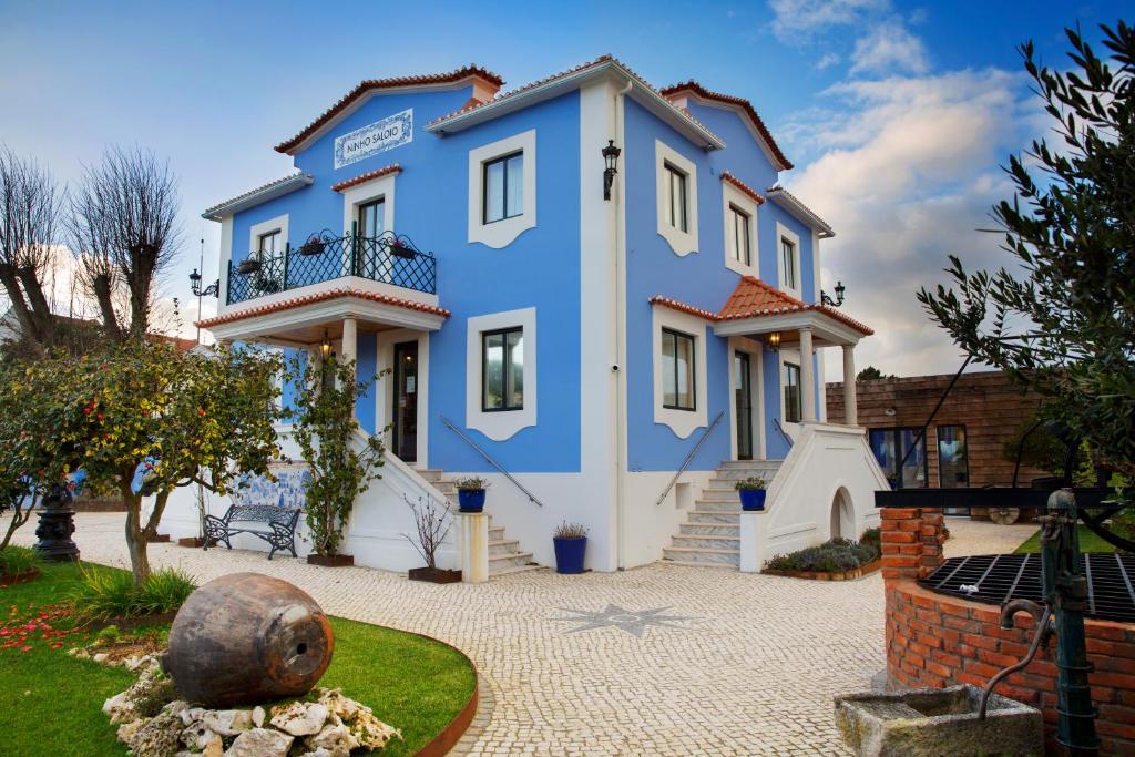 a blue and white house with a courtyard at NINHO SALOIO in Venda do Pinheiro