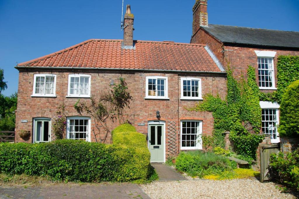 an old brick house with a red roof at 2 Hope Cottage in Spilsby