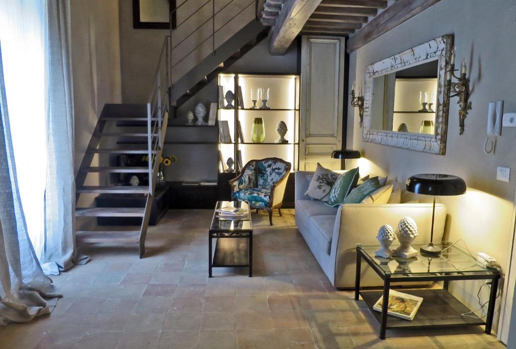 een woonkamer met een bank en een trap bij Stylish apartment in the historic center of Cortona in Cortona