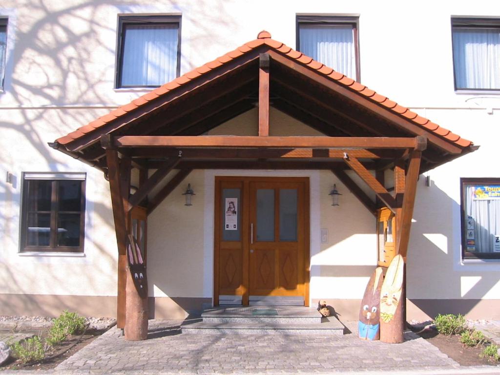 uma pequena casa com uma porta de madeira em frente em Gasthof Bogenrieder em Waidhofen