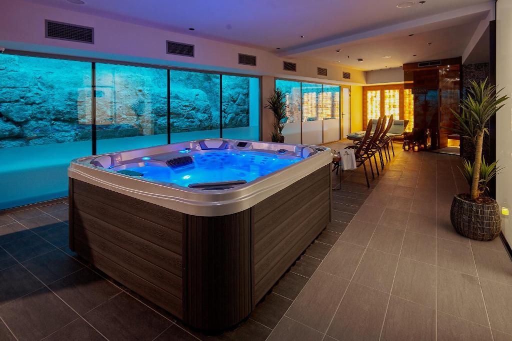 a jacuzzi tub in a room with an aquarium at Hotel Memories OldTown in Budapest