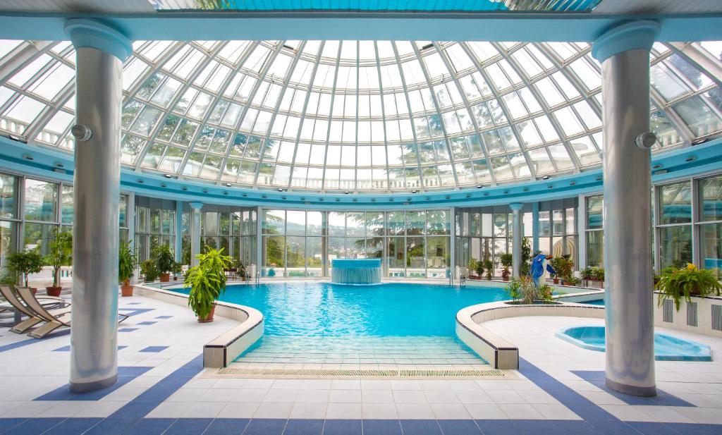 ホスタにあるMys Vidny Health Resortのガラス天井の建物内のプール