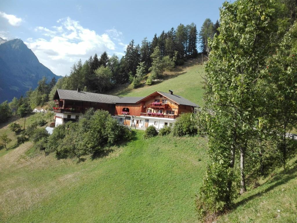 a large house on a hill in a field at Obertimmeltaler in Matrei in Osttirol