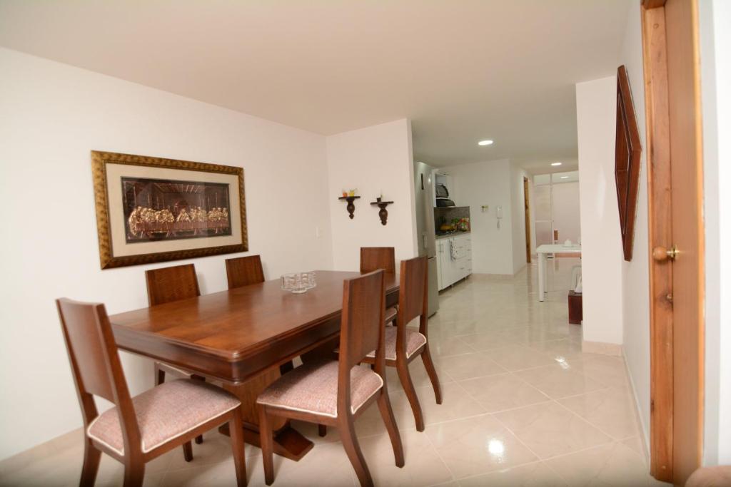ein Esszimmer mit einem Holztisch und Stühlen in der Unterkunft Acogedor Apartamento 2 Habitaciones S31 in Envigado